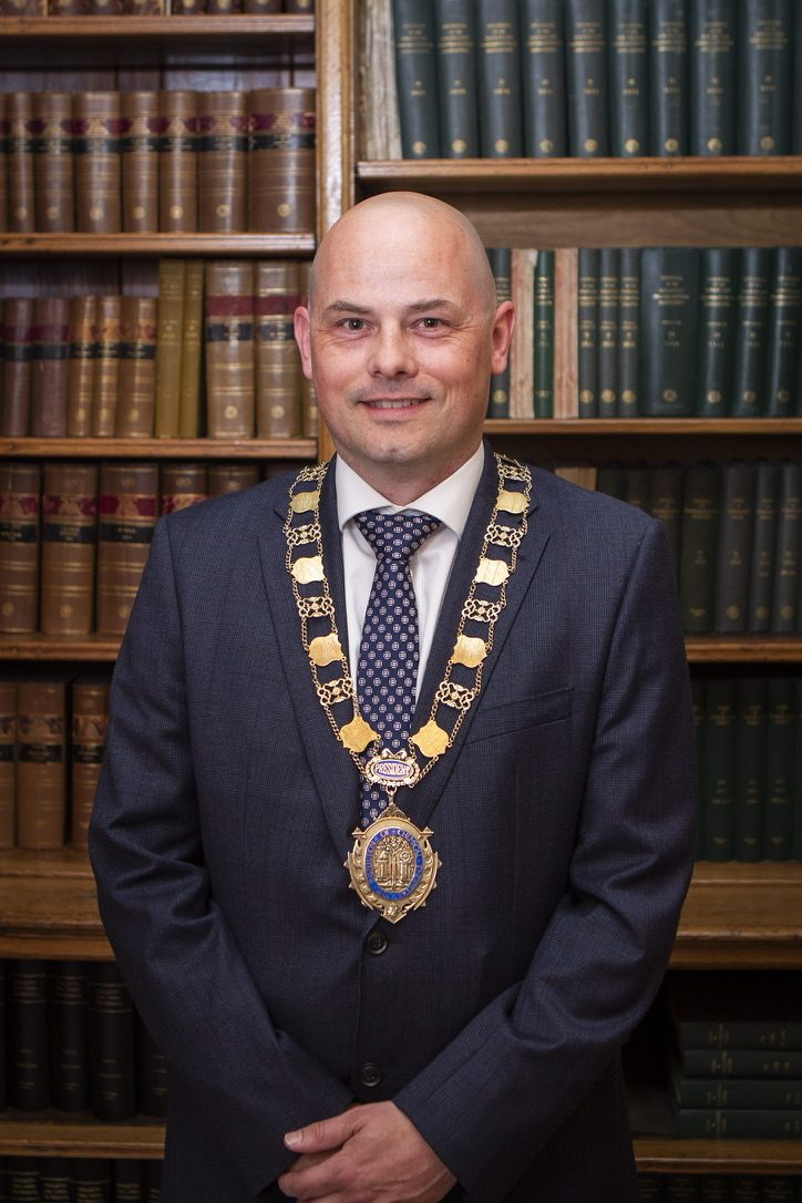 Mark Apsey wearing the IChemE presidential chain of office in a library